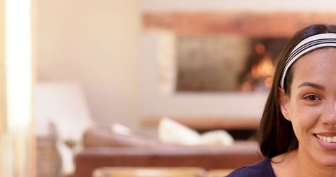 Woman relaxes by fireplace with peaceful smile