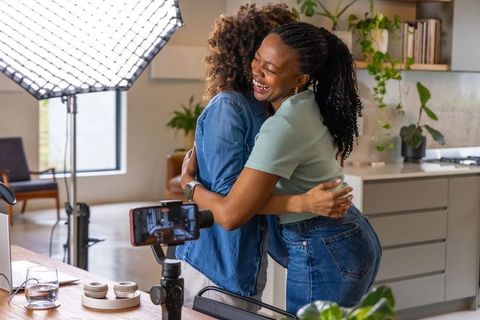 African american creators hugging in home studio kitchen celebrating collaboration and joy