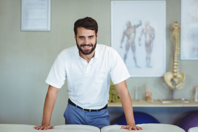 This image shows a smiling physiotherapist standing in a clinic, conveying a sense of professionalism and friendliness. Ideal for use in healthcare websites, medical brochures, physiotherapy advertisements, and wellness blogs to illustrate professional healthcare services and patient care.