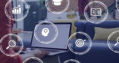 Typing student working on laptop with digital learning hud icons in modern home lounge