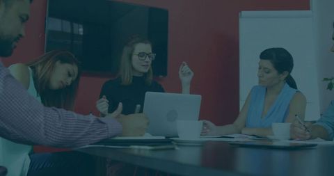 Female Leader Guiding Team Meeting with Laptop and Flipchart in Modern Conference Room