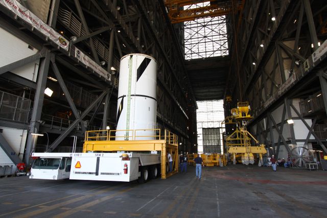 CAPE CANAVERAL, Fla. – At NASA's Kennedy Space Center in Florida, the Ares I-X forward center segment arrives in the transfer aisle of the Vehicle Assembly Building, or VAB.  The launch vehicle is being assembled in the VAB's High Bay 3.  Part of the Constellation Program, the Ares I-X is the test vehicle for the Ares I, which is the essential core of a space transportation system that eventually will carry crewed missions back to the moon, on to Mars and out into the solar system . The Ares I-X flight test is targeted for no earlier than Aug. 30.  Photo credit: NASA/Jack Pfaller