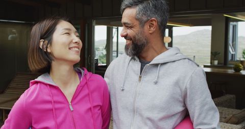 Happy Couple with Yoga Mats Smiling on Terrace
