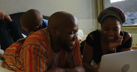 Warm African American Family Time with Laptop on Bed