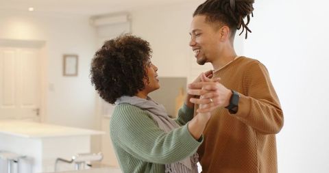 African american couple dancing in bright modern kitchen showing intimacy and home joy
