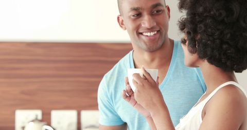 Young couple enjoying morning beverage together in kitchen