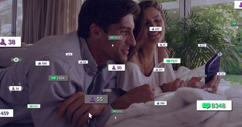 Couple relaxing on bed sharing smartphone with social media engagement overlays