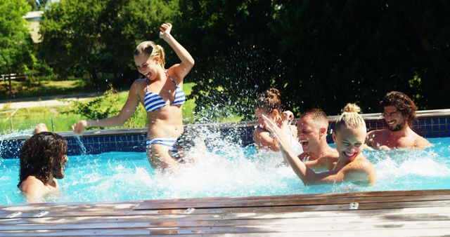 A group of young Caucasian adults enjoy a sunny day by splashing around in an outdoor swimming pool, with copy space. Their cheerful expressions and active engagement capture the essence of summer fun and friendship.