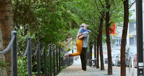 Romantic Embrace on Tree-Lined Urban Street in City