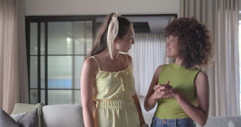 Multiracial friends chatting and laughing in modern living room with cozy decor