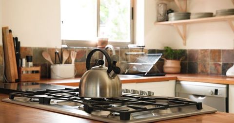 Modern kitchen with stainless steel kettle on gas cooktop