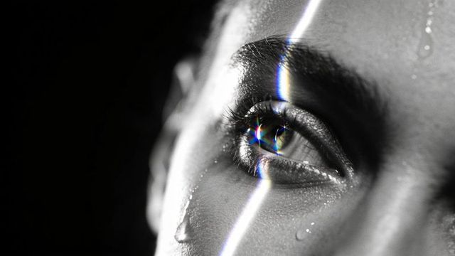 Gazing tearful eye reflecting prism light monochrome close-up conveying vulnerability