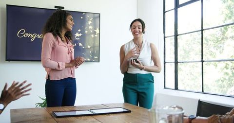 Diverse colleagues celebrating employee achievement in modern office