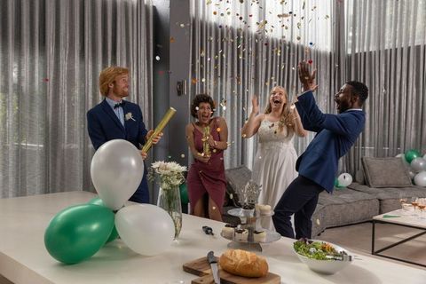 Diverse Newlyweds Celebrate with Confetti in Modern Living Room