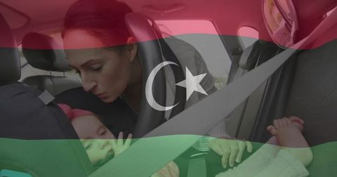 Mother ensuring baby safety in car seat