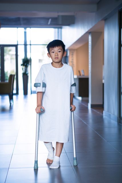Boy patient walking with crutches in corridor - Download Free Stock Photos Pikwizard.com