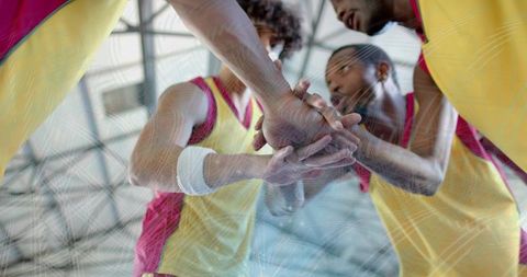 Unity and determination: hand huddle of basketball team in gym