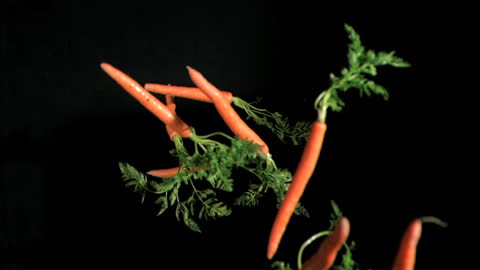 Fresh Carrots Falling in Slow Motion Against Black Backdrop