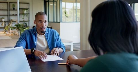 African American coworkers reviewing documents and collaborating in modern bright office