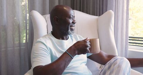 Serene Mature Man Enjoying Coffee in Bright Living Room