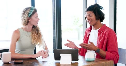 Colleagues Brainstorming with Tablet and Coffee in Modern Office
