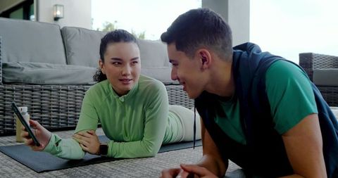 Diverse Friends Relax on Patio with Smartphone & Yoga Mats