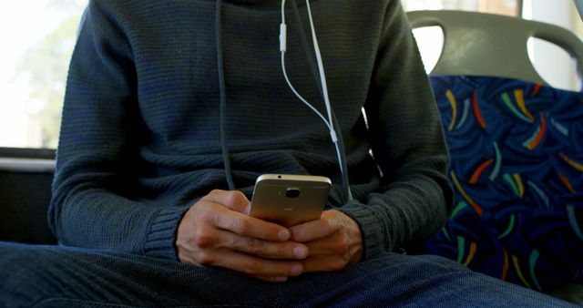 Person Wearing Headphones Using Smartphone on Public Transport - Download Free Stock Images Pikwizard.com