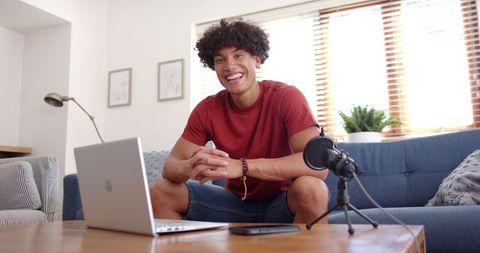 Confident Podcaster Working from Home with Laptop and Microphone