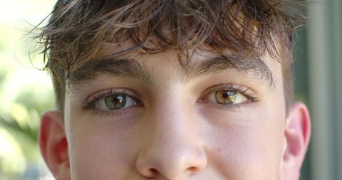 Close-up teen male portrait with damp brown hair and hazel eyes window light headshot soft