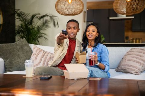 Relaxing African American Couple Enjoying Takeout and TV