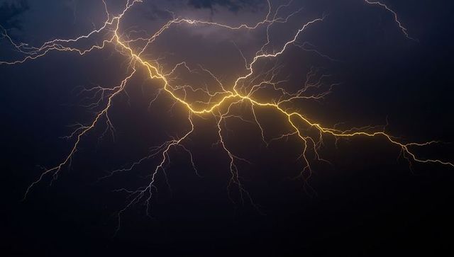 Bright Yellow Lightning Bolts in Dramatic Night Sky