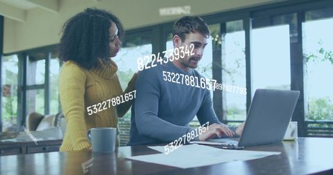 Diverse Couple Collaborating on Laptop with Data Overlay