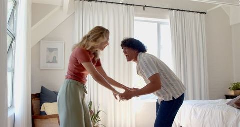 Couple Laughing and Bonding in Sunlit Modern Bedroom
