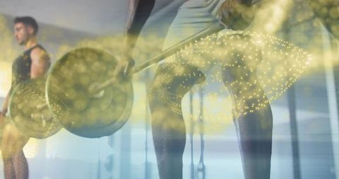 Athlete lifting loaded barbell deadlift with golden bokeh overlay in mirrored gym