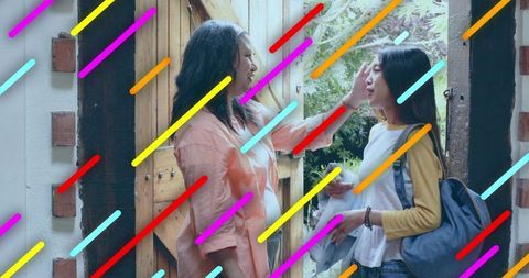 Mother checking daughter forehead at wooden doorway with backpack and garden view
