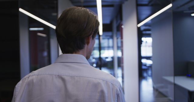 Businessman Walking Down Office Corridor with Glass Walls - Download Free Stock Images Pikwizard.com