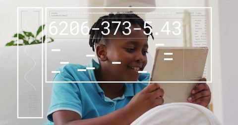 Cheerful boy engaging with tablet overlayed by digital data, modern living room