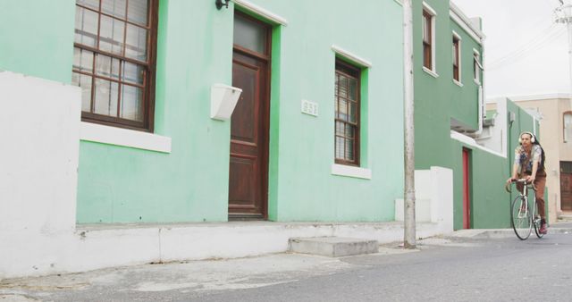 Woman Riding Bicycle Along Colorful Houses - Download Free Stock Images Pikwizard.com