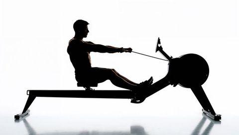 Silhouette male rowing on indoor ergometer rowing machine for cardio strength training
