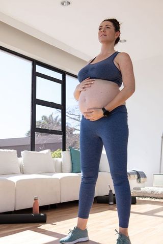 Pregnant woman practicing mindfulness in modern living room