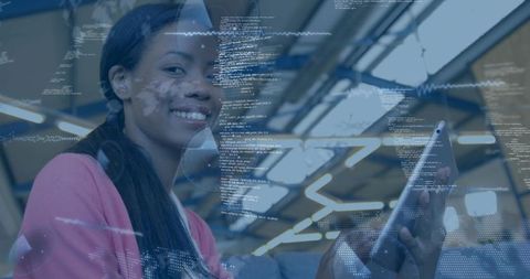 Smiling woman using tablet with holographic code, analytics charts and world map overlays