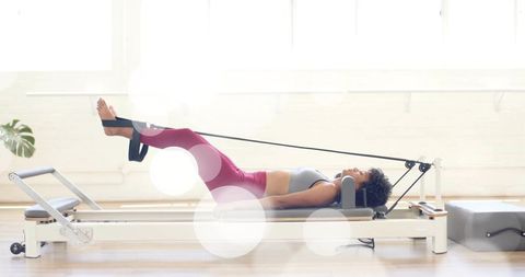 Reformer pilates practicing core strength and flexibility in bright minimal studio