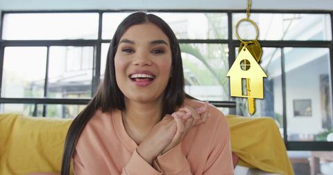 Happy woman celebrating new home with golden key symbol