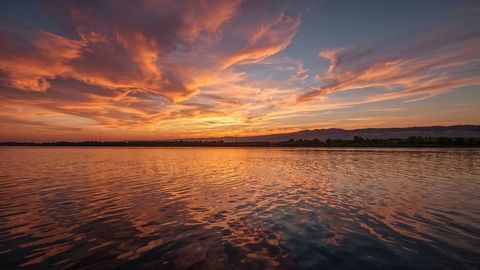 Tranquil Lake Sunset with Reflective Water and Orange Clouds