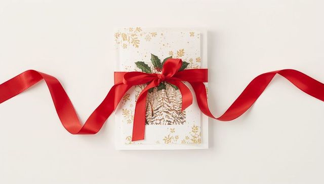Elegant Christmas Gift Wrapped in Gold Pine Foil with Red Satin Ribbon and Holly