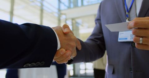 Businesspeople Shaking Hands and Exchanging Cards - Download Free Stock Images Pikwizard.com