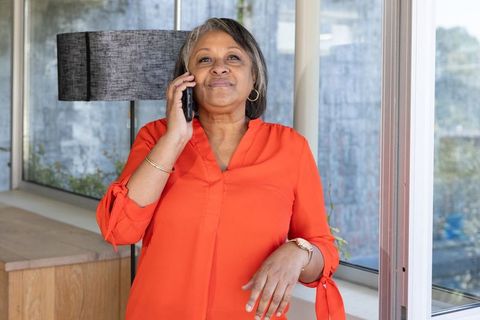 Confident Senior Woman on Phone Beside Bright Window