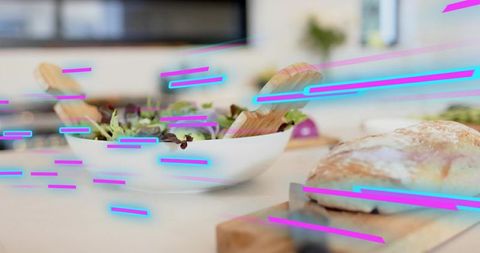 Neon glitch kitchen featuring bowl of salad with wooden servers and rustic bread