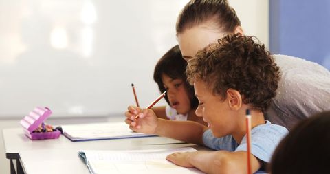 Teacher Assisting Young Students in Classroom Activity - Download Free Stock Images Pikwizard.com