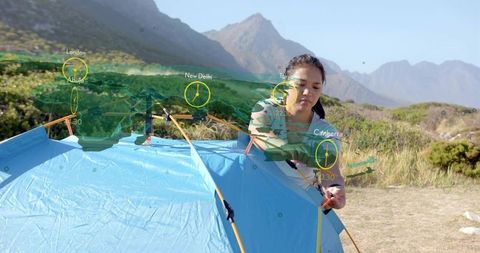 Camper Setting Up Tent With AR Map Overlay in Mountain Scenery